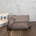 Close-up detail of the grey retro messenger bag highlighting soft texture and wide strap. - Coffee Gray