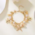 Detailed view of bohemian starfish and shell charm bracelet with faux pearls and gold chain. - Ocean Style Pendant Bracelet (BR23Y0327)