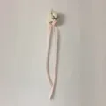 Detailed close-up view of elegant pink artificial flower corsage with long ribbon details. - Corsage / Headwear / Pink White
