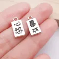 Close-up view of silver alloy rectangular charms featuring engraved blessing text details. - Dreams Come True Double-Sided Pendant (18417) / 8x16mm (1 Piece) / Antique Silver