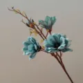 Close up detail of blue artificial magnolia flower branch with realistic EVA petals. - Teal