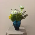 Kunstbloemenboeket detail, blauwe glazen vaas voor woondecoratie en fotoweergave. - Bloem + Blauwe Glazen Vaas
