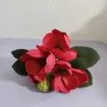 Vue détaillée d'un bouquet de fleurs de magnolia artificielles rouges avec des feuilles vertes. - Rouge Foncé