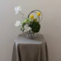 Vue de détail d'un arrangement floral artificiel de luxe moderne avec orchidées dans un vase. - Fleur + Vase en Verre Gaufré Transparent (Hauteur 9cm)