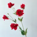 Detailed shot of artificial red anemone flower stem with green leaves for home decor. - Red