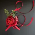 Elegant red artificial flower corsage boutonniere with ribbons for wedding photography. - Wrist Corsage