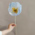 Detailed close-up of the artificial poppy flower showing delicate blue and white petals and stamen. - Ice Blue