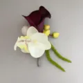 Detailed close up view of artificial calla lily and orchid boutonniere for men suit. - Corsage