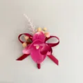 Close-up view of the exquisite magenta orchid boutonnière featuring delicate red ribbon details. - Small Phalaenopsis Boutonniere / S