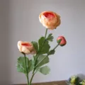 Close-up detail of 3-head artificial tea rose flower branch, showing petals, buds and green leaves. - Champagne