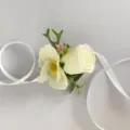 Dettaglio corsage da polso con rosa artificiale bianca per fotografia di matrimonio. - Stile C
