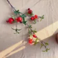 Ramo di melograno artificiale con frutti rossi e fiori, dettaglio decoro casa. - Rosso