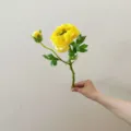Artificial flower detail shot showing yellow ranunculus bloom and green leaf stem clearly. - Dark Yellow