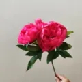 Detailed close-up view of artificial pink peony silk flower branch for home interior decor. - Rose Red