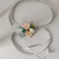 Closeup detail of artificial rose wrist corsage with elegant silver ribbon for wedding. - Wrist Corsage