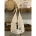 Vista dettagliata di un'elegante borsa a spalla in maglia traforata con atmosfera estiva. - Bianco avorio