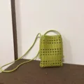 Détail en cuir tressé du sac téléphone vert avec motif ajouré et bandoulière fine. - Vert olive