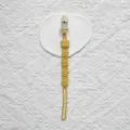 Detailaufnahme eines Babynuckelhalters aus Silikon mit süßem Cartoon-Kuh-Design in Gelb. - Plastikclip-Stil / Gelb