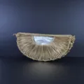 Vue détaillée du sac croissant tressé à la main, mettant en valeur la texture et la doublure. - Or