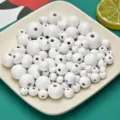 Vue détaillée de perles rondes en bois blanc, tailles variées pour accessoires de bijoux. - 8mm (Trou de 2mm) / Blanc