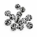 Close-up view of 16mm black and white cow print wooden beads, ideal for DIY crafts. - Cow Print