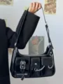 Sac porté épaule de motard en cuir verni noir avec poches multiples et chaîne style Y2K - Noir