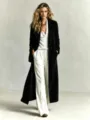 Details of the black suede long coat paired with a chic white blouse and wide-leg trousers. - S / Black