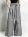 Detail shot of high-waisted grey wide-leg trousers featuring a paperbag waist and belt. - S / Gray