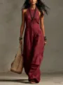 Detail view of a chic burgundy sleeveless halter linen jumpsuit with woven tote bag. - Burgundy
