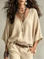 Close-up detail of women's V-neck linen top paired with layered necklaces and casual belt. - XS / Apricot
