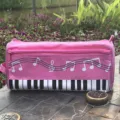Estuche de lona rosa con teclas de piano y notas musicales para material escolar. - Rosa