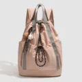 Casual pink nylon drawstring backpack for women, lightweight travel daypack with baseball charm. - Pink
