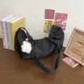 Minimalist black nylon shoulder bag for women, trendy underarm crescent bag with cute bear. - Black with White Bell Pendant