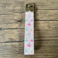 Primo piano del cordino portachiavi in misto cotone con stampa floreale e metallo bronzo. - Floreale Rombo Rosa (10)