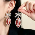 Detailed close-up of stylish football bow earrings with rhinestones and glitter for fans. - White K/Silver