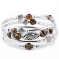 Mehrlagiges Wickelarmband aus Metallreifen mit braunen Natursteinperlen und floralen Anhängern. - Tigerauge Armband
