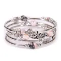 Detalle en primer plano de pulsera envolvente multicapa con cuentas de piedra natural y dijes. - Pulsera de Piedra Cebra Rosa