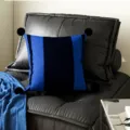 Vista detallada de cojín azul y negro moderno a rayas con pompones esponjosos en el sofá. - Doble Cara 35x35cm (Funda Sin Relleno) / Rayas Azul Marino Pompón Negro
