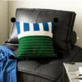 Decorative throw pillow with blue white stripes, green grid pattern, and black pom poms. - Caramel Stripe Black Pom-pom