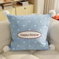 Detailed view of soft blue polka dot cushion with pom-poms and embroidered text for cozy sofa decor. - Blue Polka Dot Rectangle