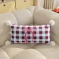 Charming blue and red plaid throw pillow with pink bow and pom-poms for cozy living room decor. - Blue Plaid Bowknot Long Rectangle