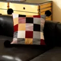 Primo piano dettagliato di un cuscino decorativo in patchwork geometrico con pompon neri. - 35x35cm Solo Federa / Pompon Nero Fiammeggiante