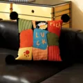 Detailed view of cute cartoon cat decorative throw pillow with black pom-poms and colorful patchwork. - Showa Black Pom-Pom
