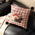 Detailed view of the plaid throw pillow with cute cartoon dog embroidery and corner pom-poms. - Black House Dog Black Pom Pom