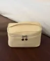 Detailansicht der gelben Kosmetiktasche mit praktischem Griff und Herz-Reißverschluss. - Extra groß / Gelb