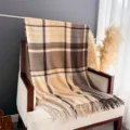 Detail view of a cozy vintage plaid cashmere-feel shawl scarf with stylish fringe edges. - Light Camel