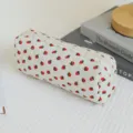 Detail view of the quilted white cosmetic bag featuring cute strawberry prints and smooth zipper. - Little Strawberry