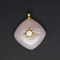 Detailed close-up shot of the rose quartz rhombus pendant featuring a gold starburst design. - Rose Quartz