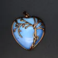 Gedetailleerd uitzicht op vintage blauwe hart kristallen hanger met bronzen tak sieraden. - Opaal