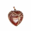 Close-up detail van de vintage brons boomtak omwikkelde rode hart kristal hanger accessoire. - Rode agaat